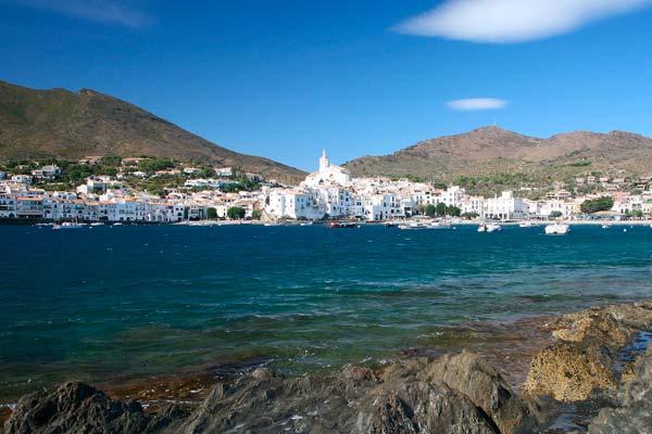 Vista de una playa de Cadaqués con la población de fondo